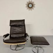Vintage leather reclining armchair and its 1970s designer ottoman.