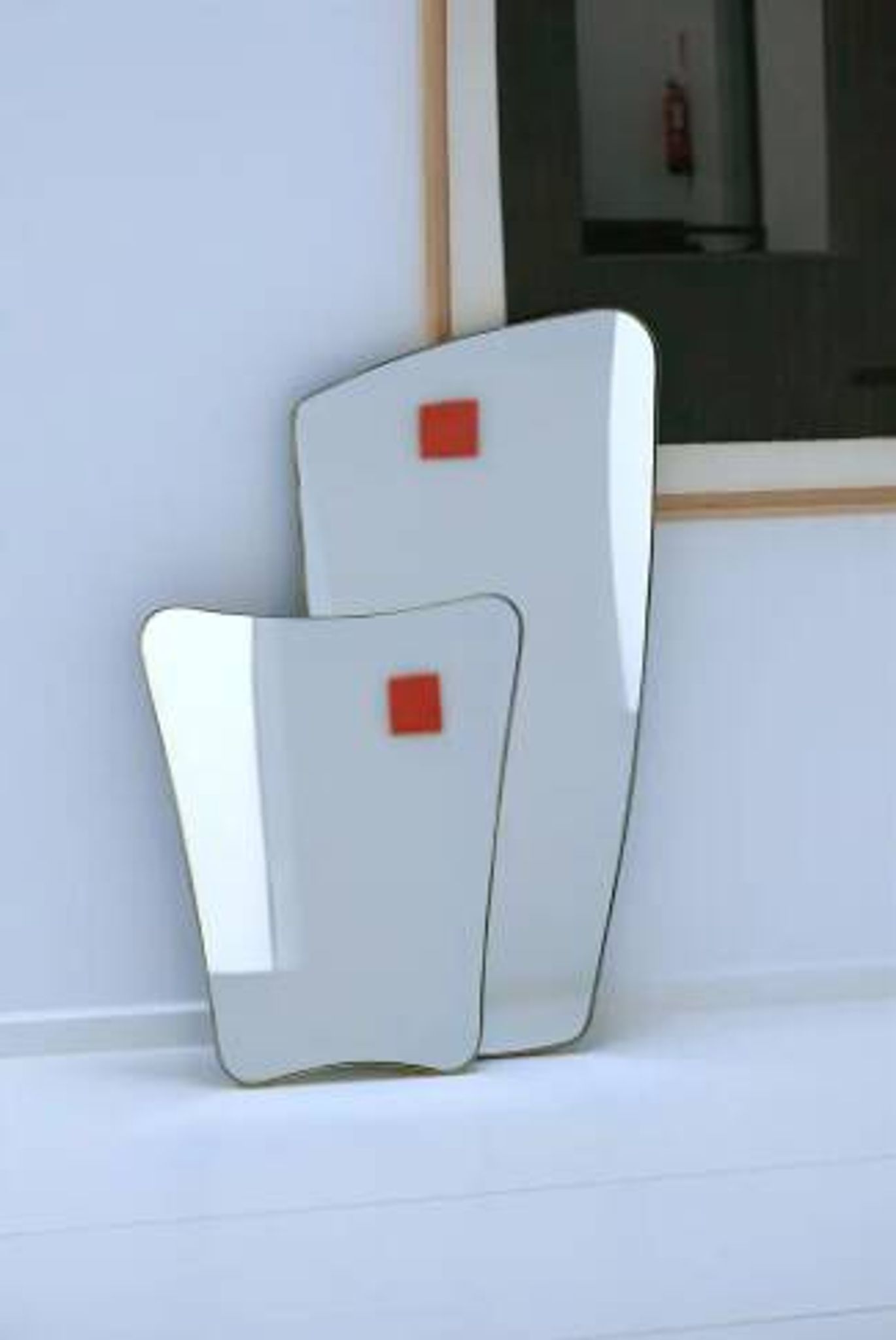 Rectangular mirror with rounded edges and a repoussé brass frame.