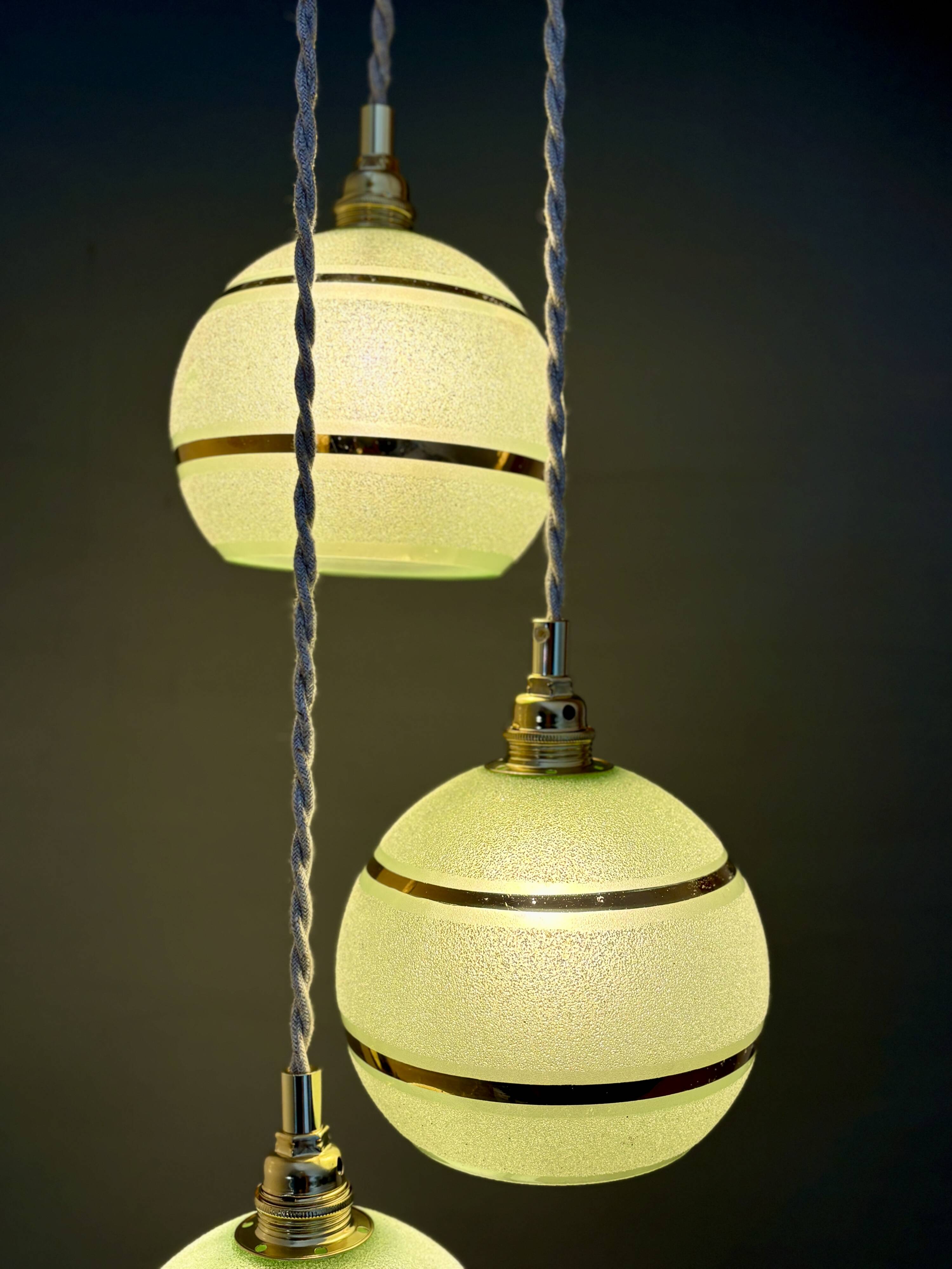 Suspension triple vintage glass globes in frosted green and gold.