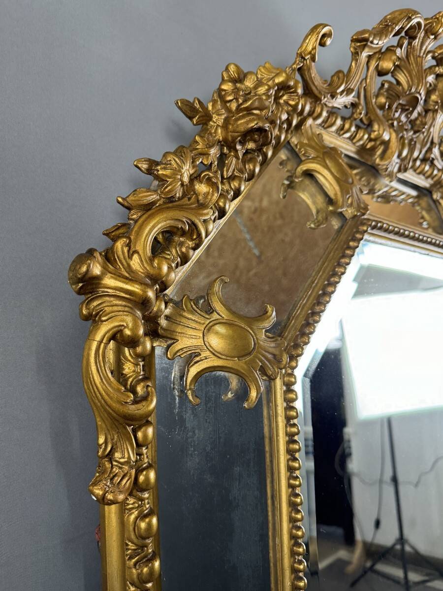 Antique octagonal mirror in richly carved gilded wood, Louis XV style.