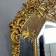 Antique octagonal mirror in richly carved gilded wood, Louis XV style.