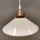 A set of hanging lamps in milky white opal glass with brass top.