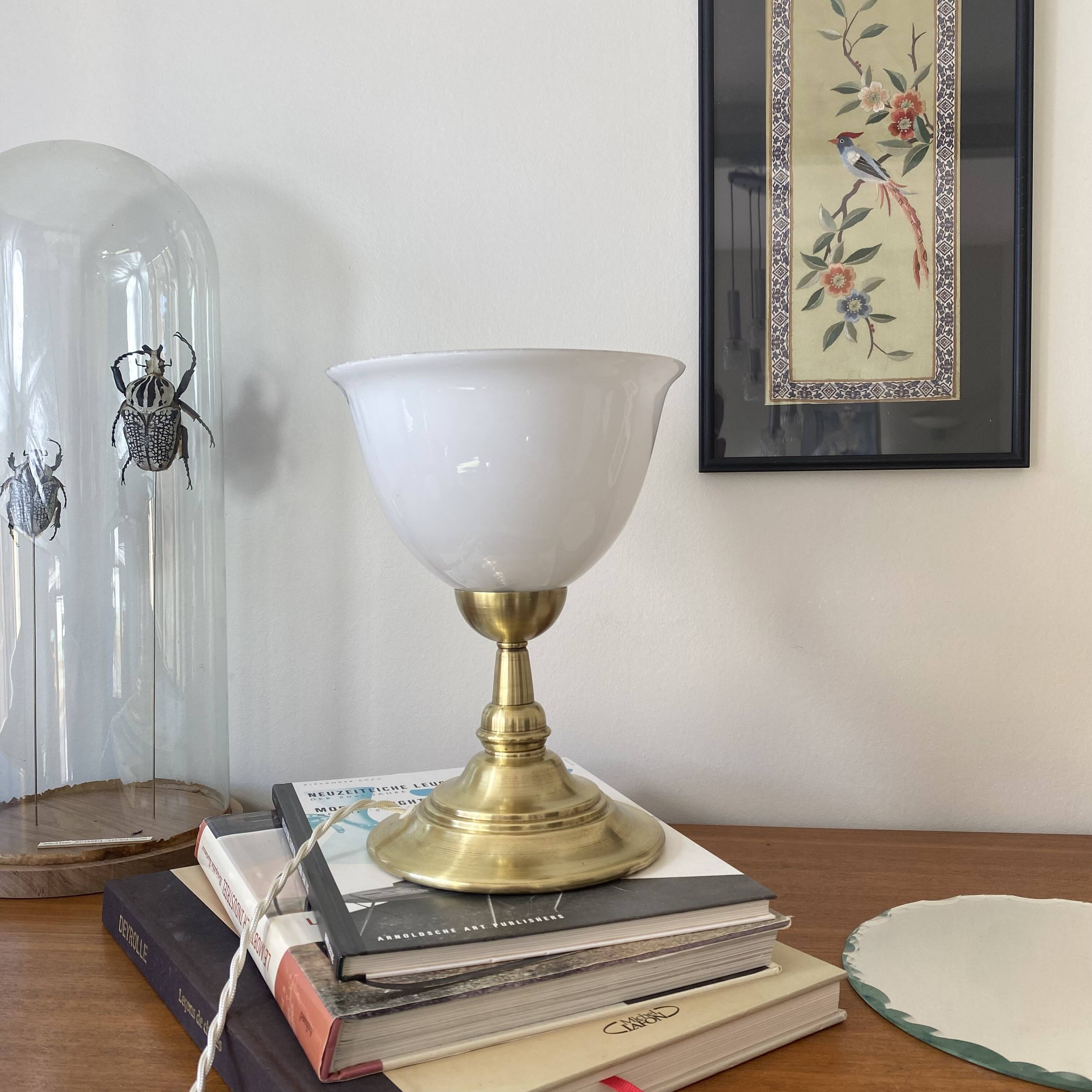 Antique white opaline glass globe table lamp with a brass base.