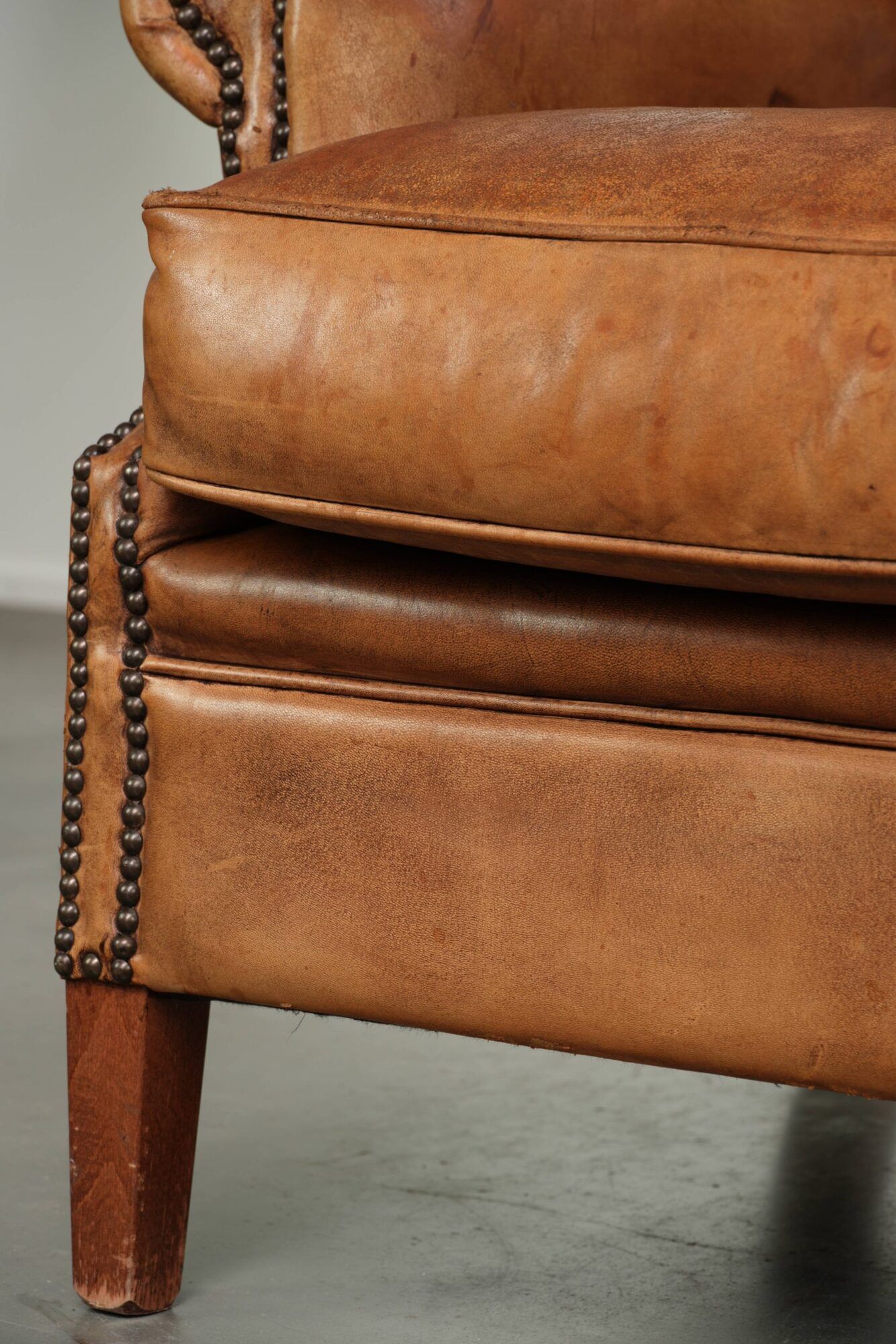 Sheepskin wingback armchair in a light cognac colour in English style