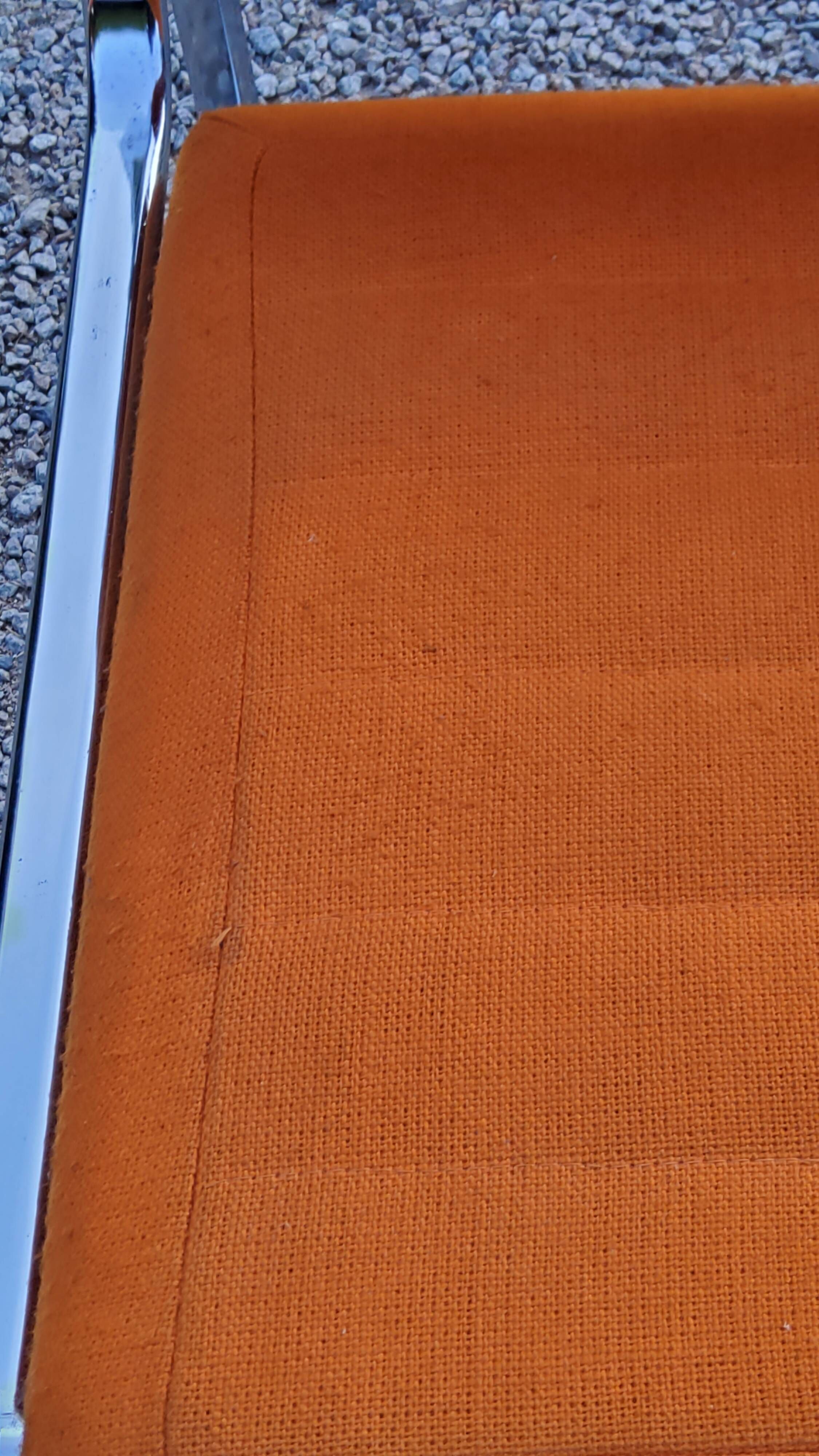 Pair of designer armchairs in orange fabrics and chrome tubes from the 70s