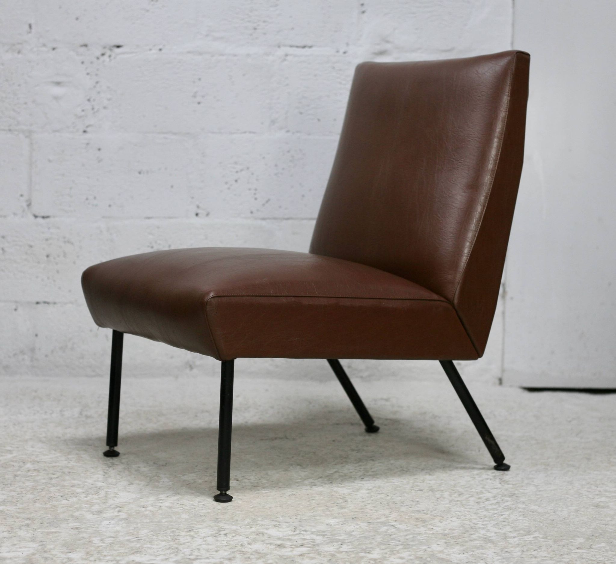 Chauffeuse, circa 1950. Simili-cuir brun.