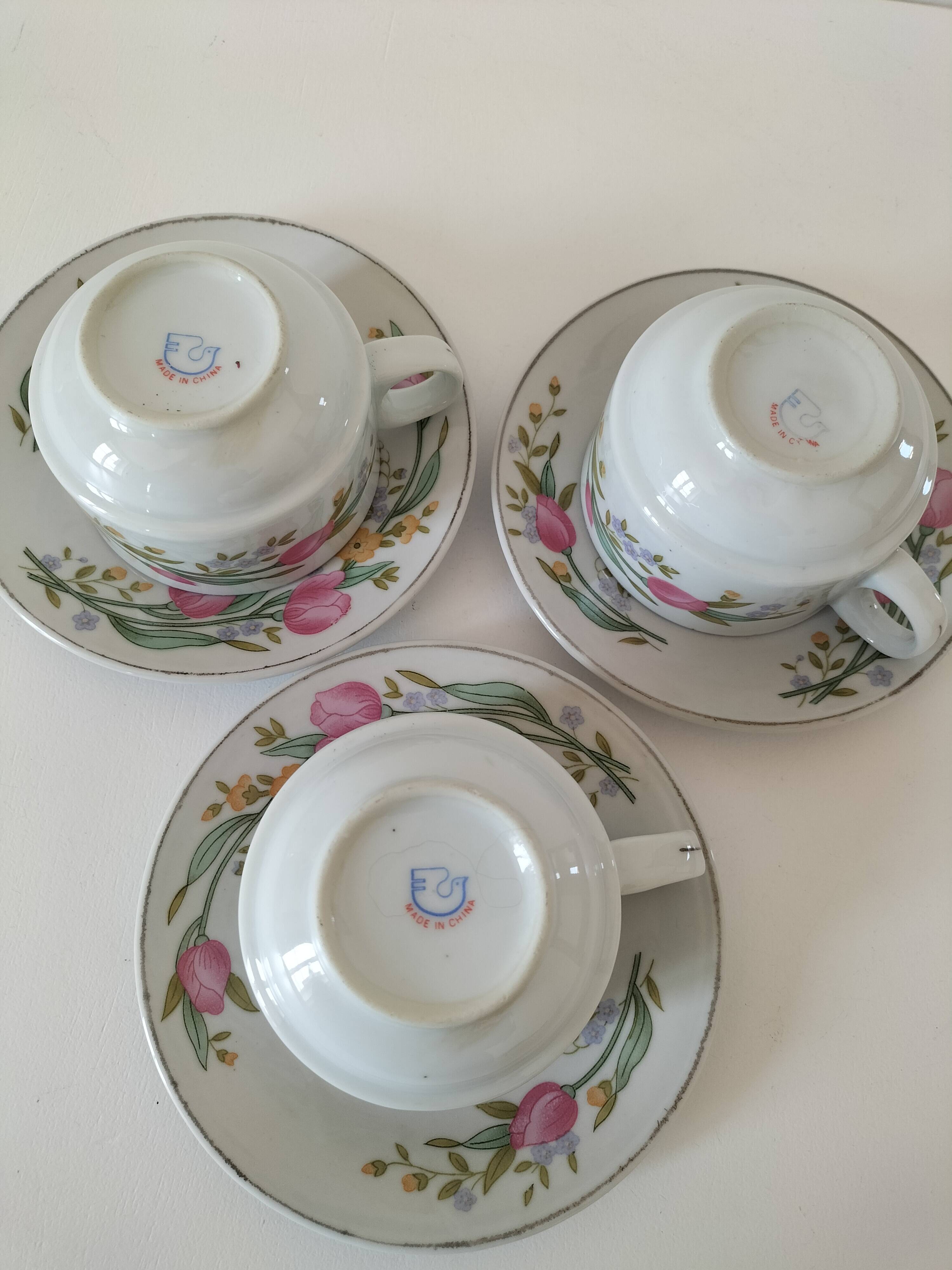 Trio of floral porcelain cups and saucers