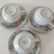 Trio of floral porcelain cups and saucers