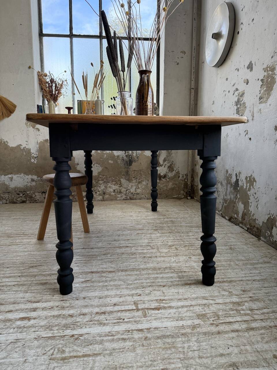 Oak farmhouse table with turned black legs.