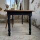 Oak farmhouse table with turned black legs.