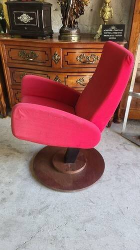 Old cinema chair with a red reclining seat.