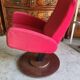 Old cinema chair with a red reclining seat.