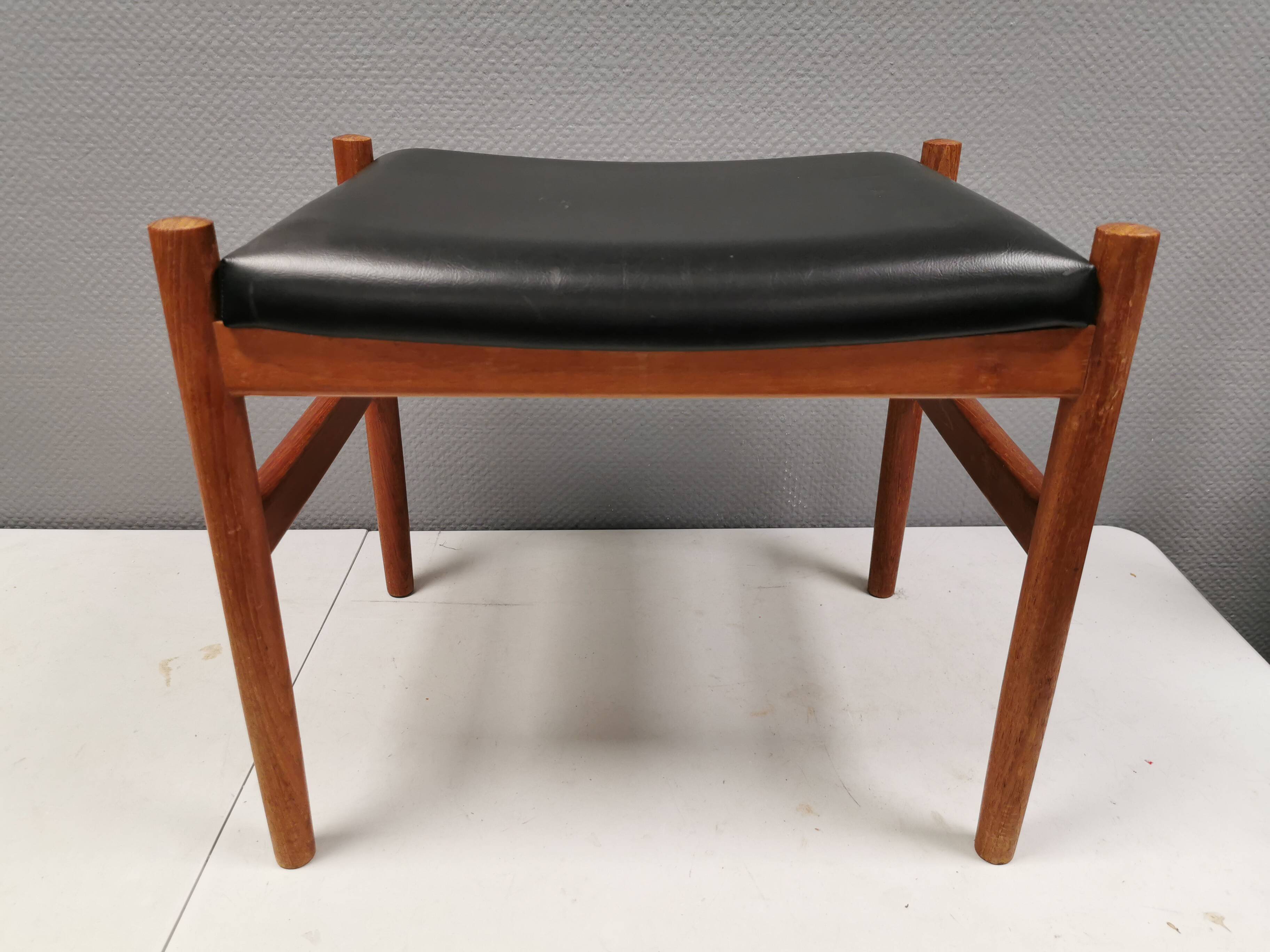 Danish designed footstool in teak wood and black skai “imitation leather”