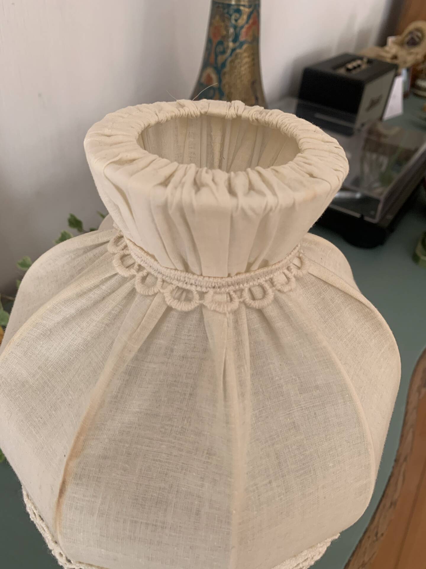 Small vintage wooden turned table lamp with a pleated shade.