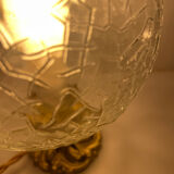 Small handcrafted globe lamp with a cracked finish and a golden brass base.