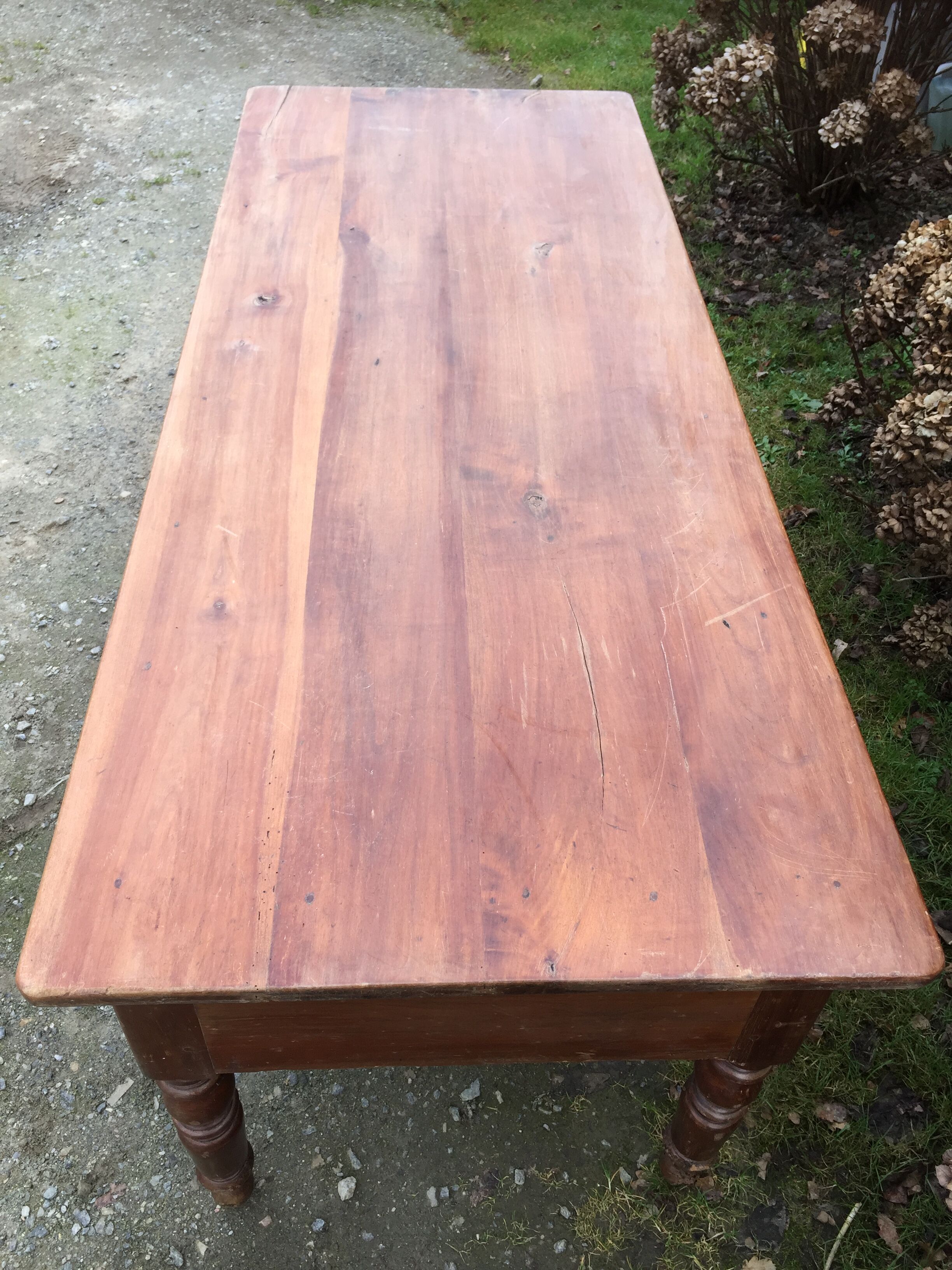 Old farmhouse table with cherry and chestnut panels with 3 drawers.