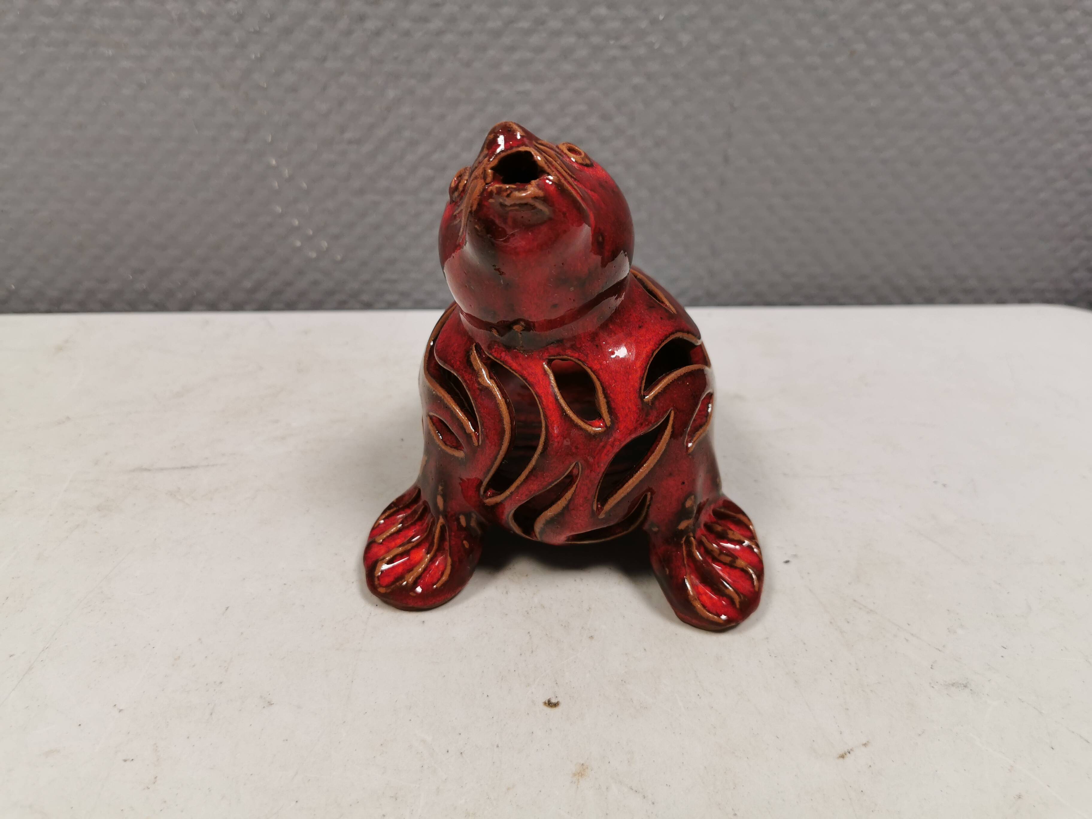 Beautiful seal in ceramic with metallic red glaze.