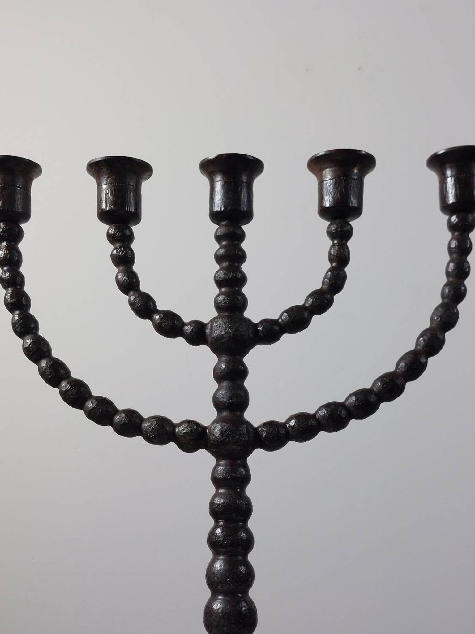 Candelabrum in the shape of a spool, skilfully forged in menorah style.