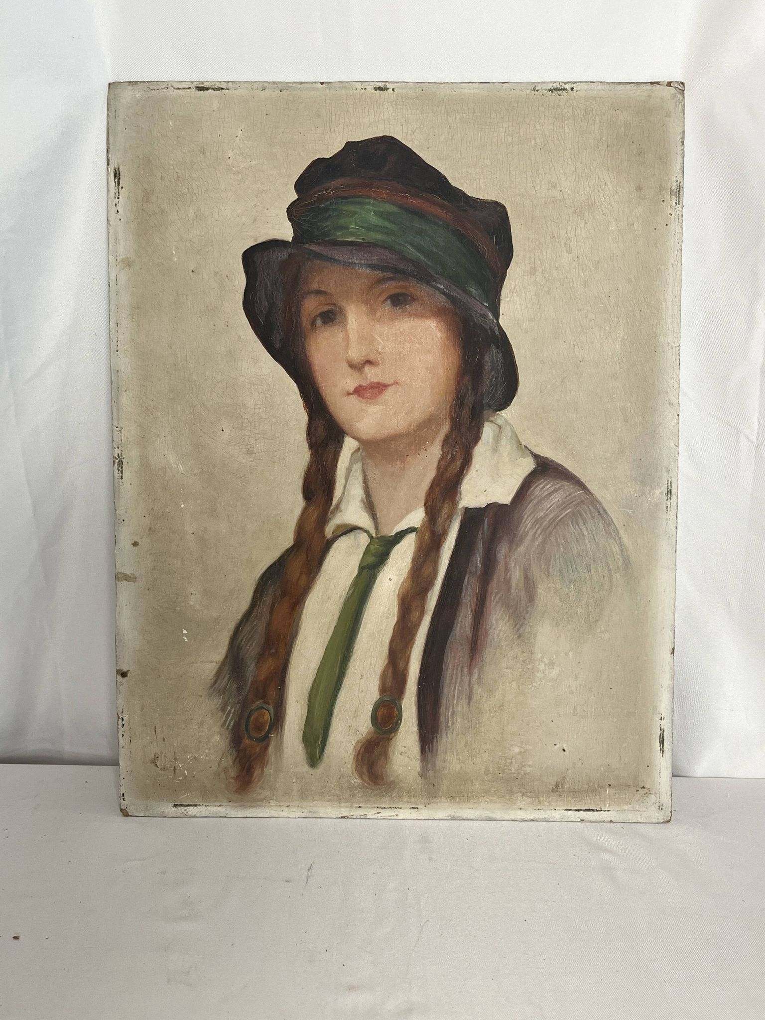 Old portrait of a young woman with braids and a hat, circa 1930