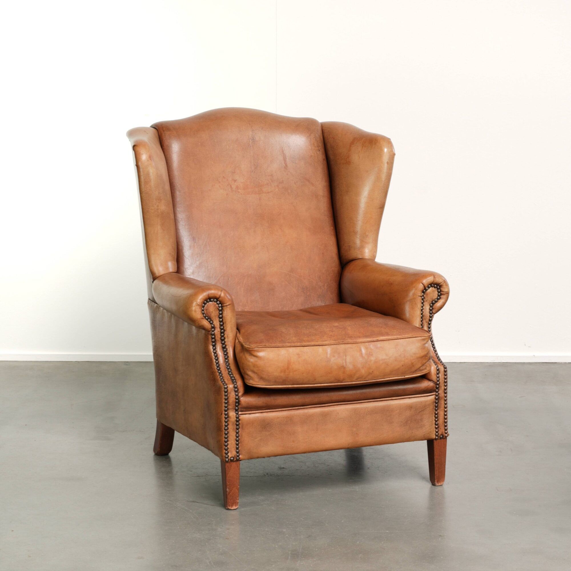 Sheepskin wingback armchair in a light cognac colour in English style