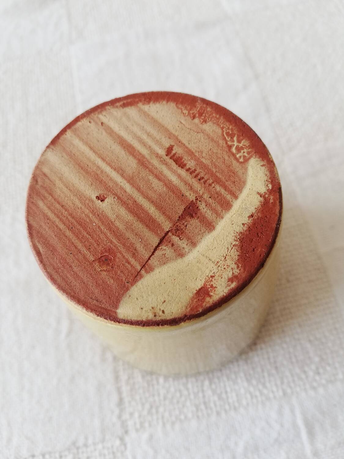 Mustard-colored ceramic cup or glass with green decor