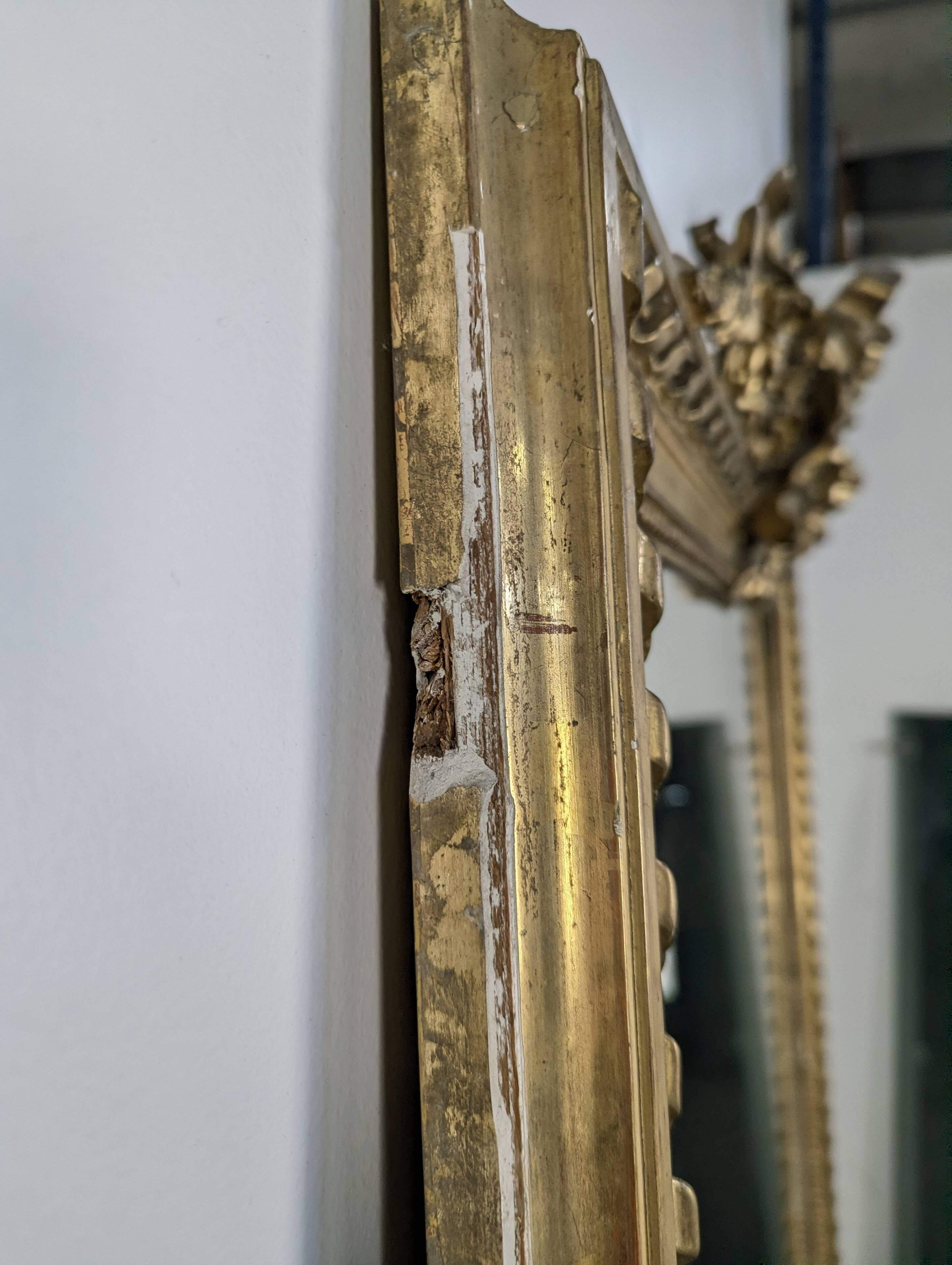 Golden Louis XVI style mirror with bouquet and shells.