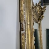 Golden Louis XVI style mirror with bouquet and shells.