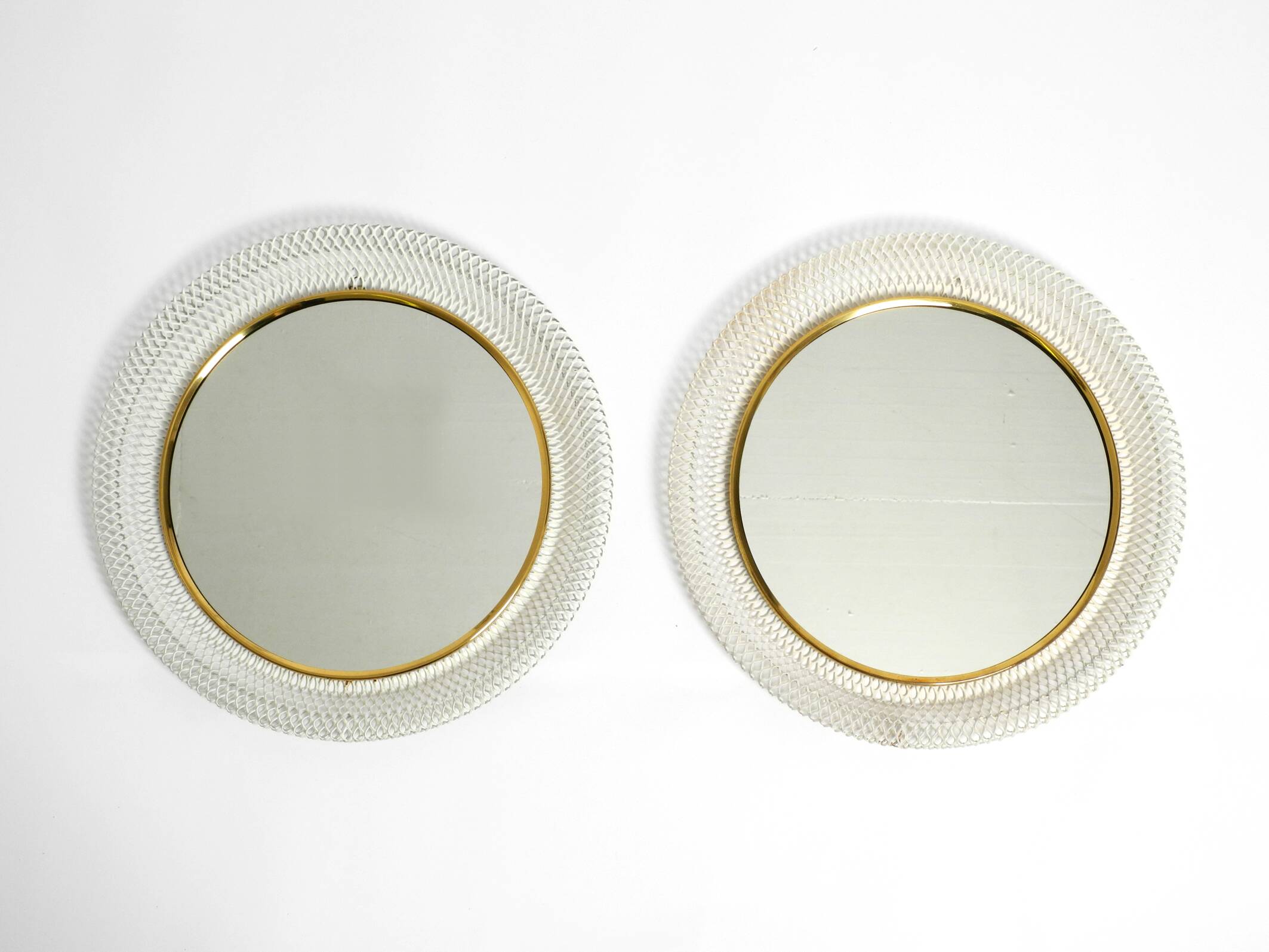 Pair of Mid Century wall mirrors with brass rim and white metal frames