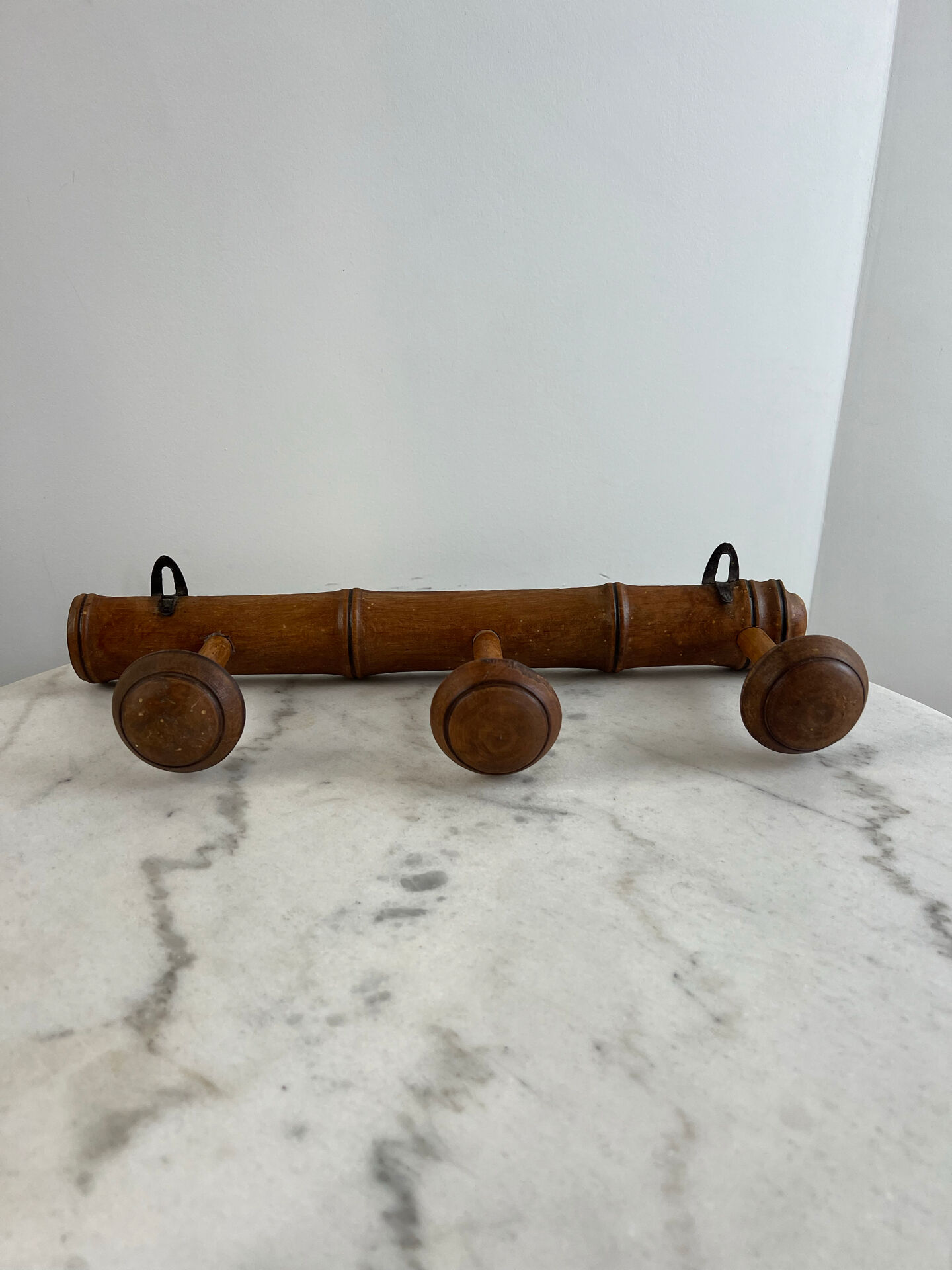 Wooden coat rack with three ball hooks.