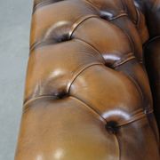 A well-maintained cowhide leather English Chesterfield armchair