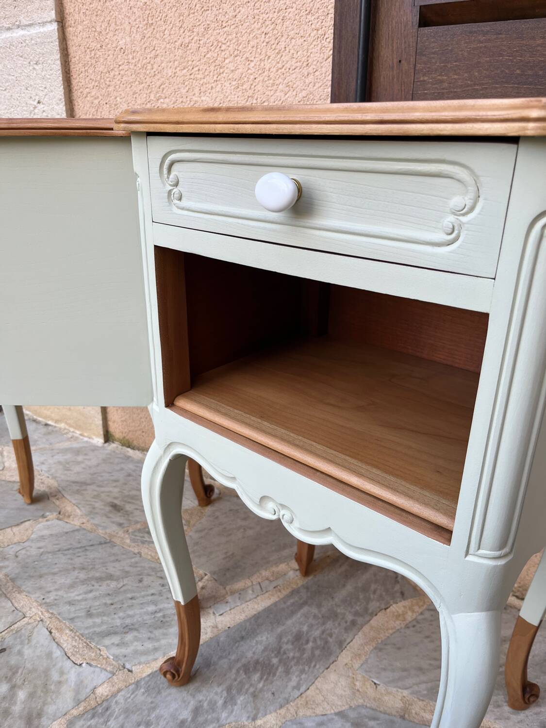 Renovated bedside tables in laurel green and light wood.