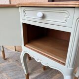 Renovated bedside tables in laurel green and light wood.