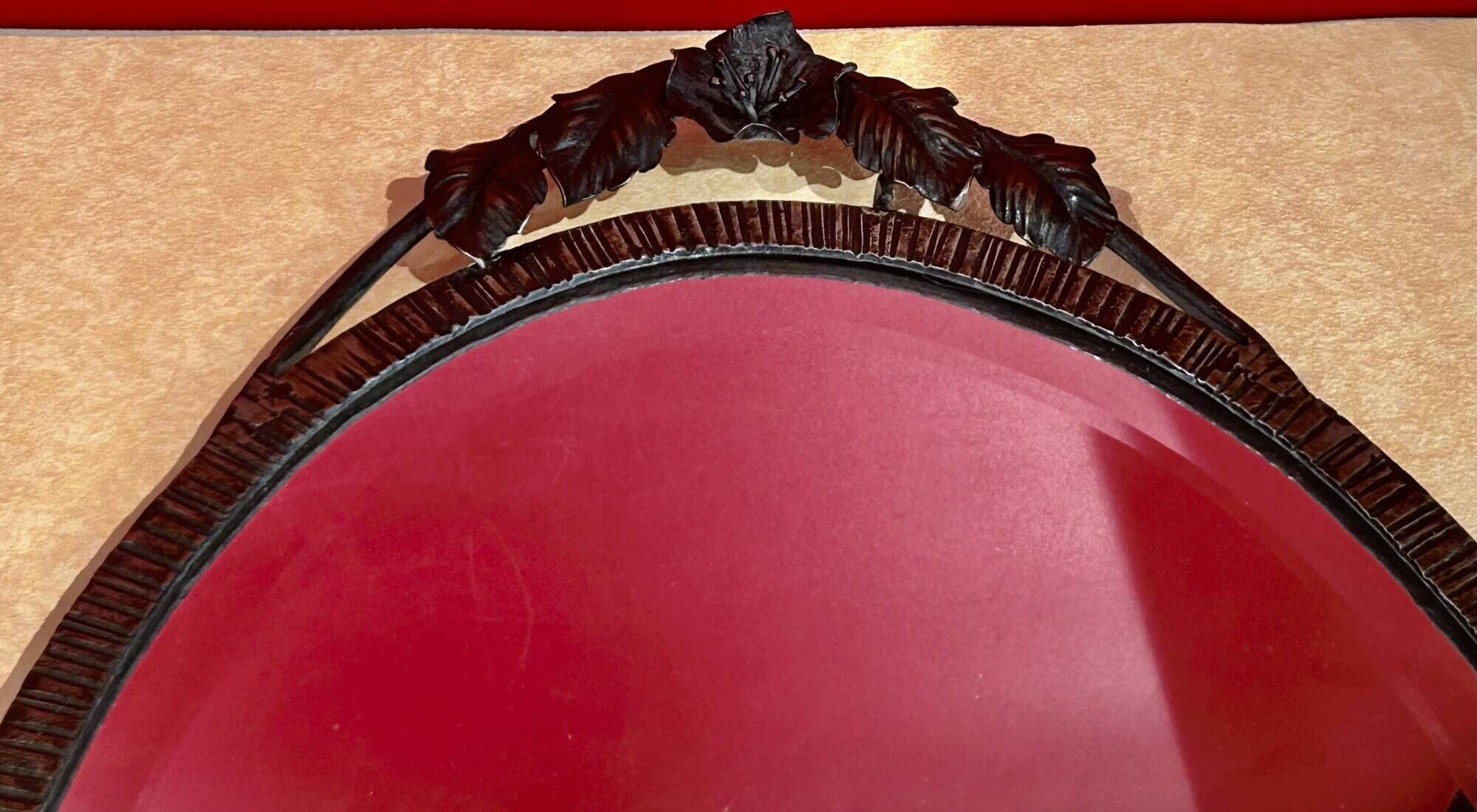Bevelled oval mirror, richly crafted Art Deco wrought iron.