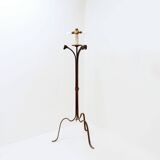 Wrought iron tripod floor lamp decorated with stylized animal heads