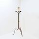 Wrought iron tripod floor lamp decorated with stylized animal heads