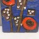 Ceramic relief in attractive blue with a motif of white/red flowers.