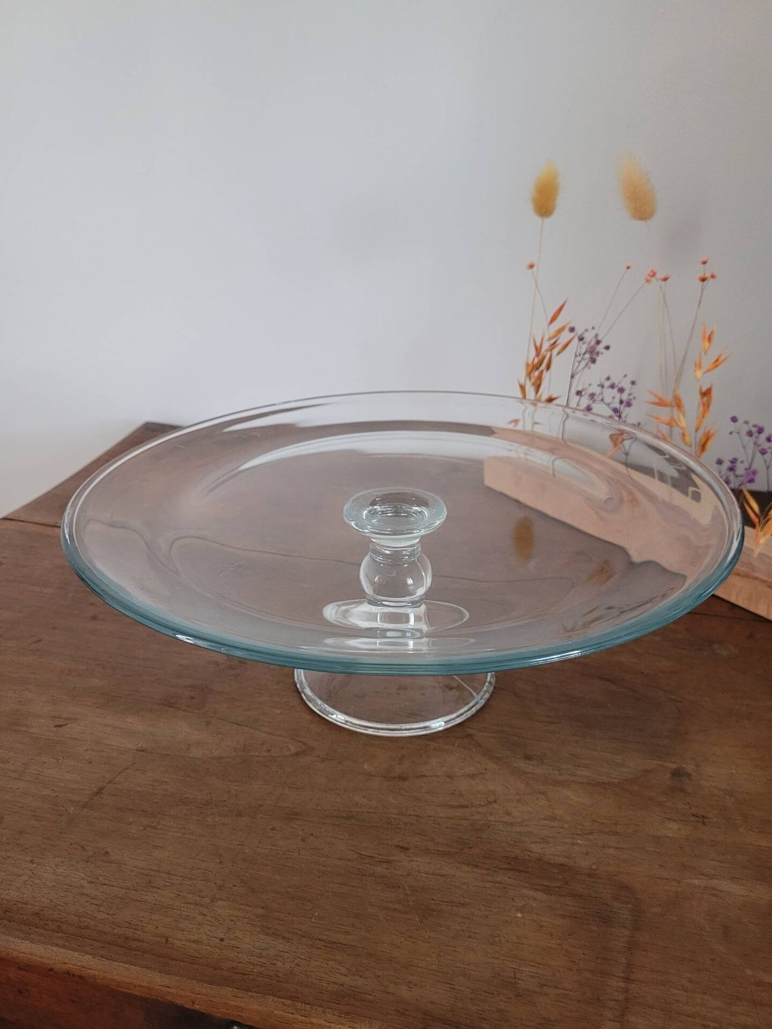 Large glass display plate mounted on a stand.
