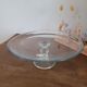 Large glass display plate mounted on a stand.