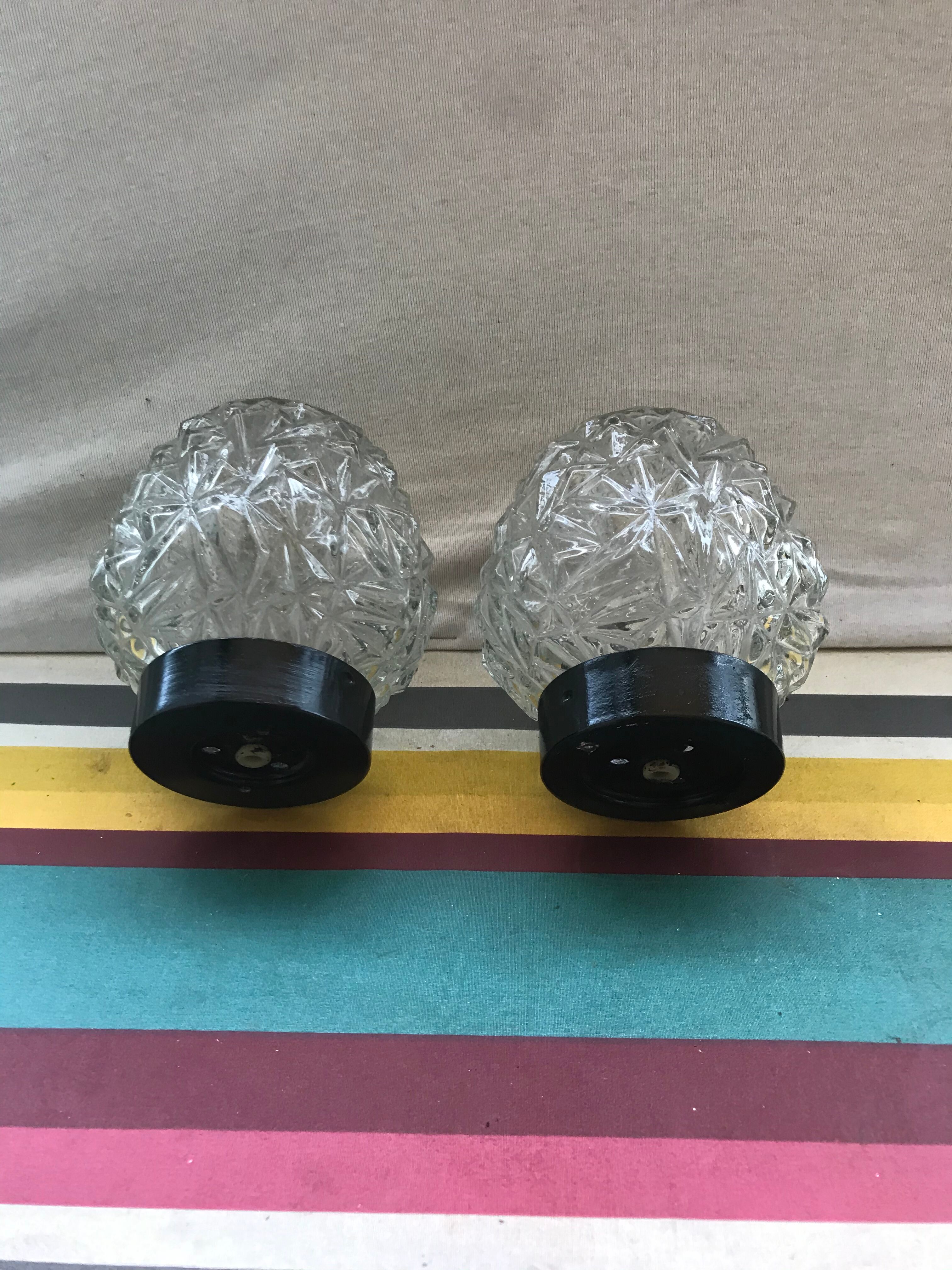 Old pair of glass moulded wall sconces with vintage black metal support