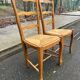 2 solid wood and rush-seated chairs in Louis XV style with shell carving from the 20th century.