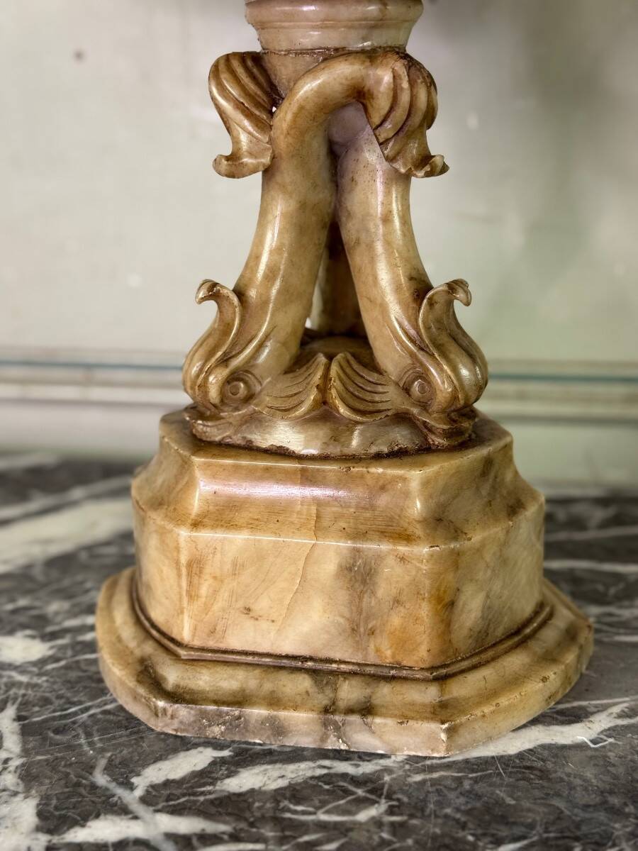 Alabaster bowl decorated with vine leaves on a base of three dolphins, circa 1880.
