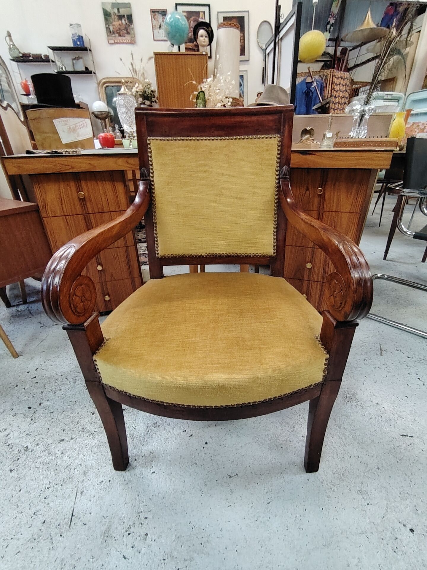 Armchair with scroll arms and sabre legs in mustard velvet, 19th century.