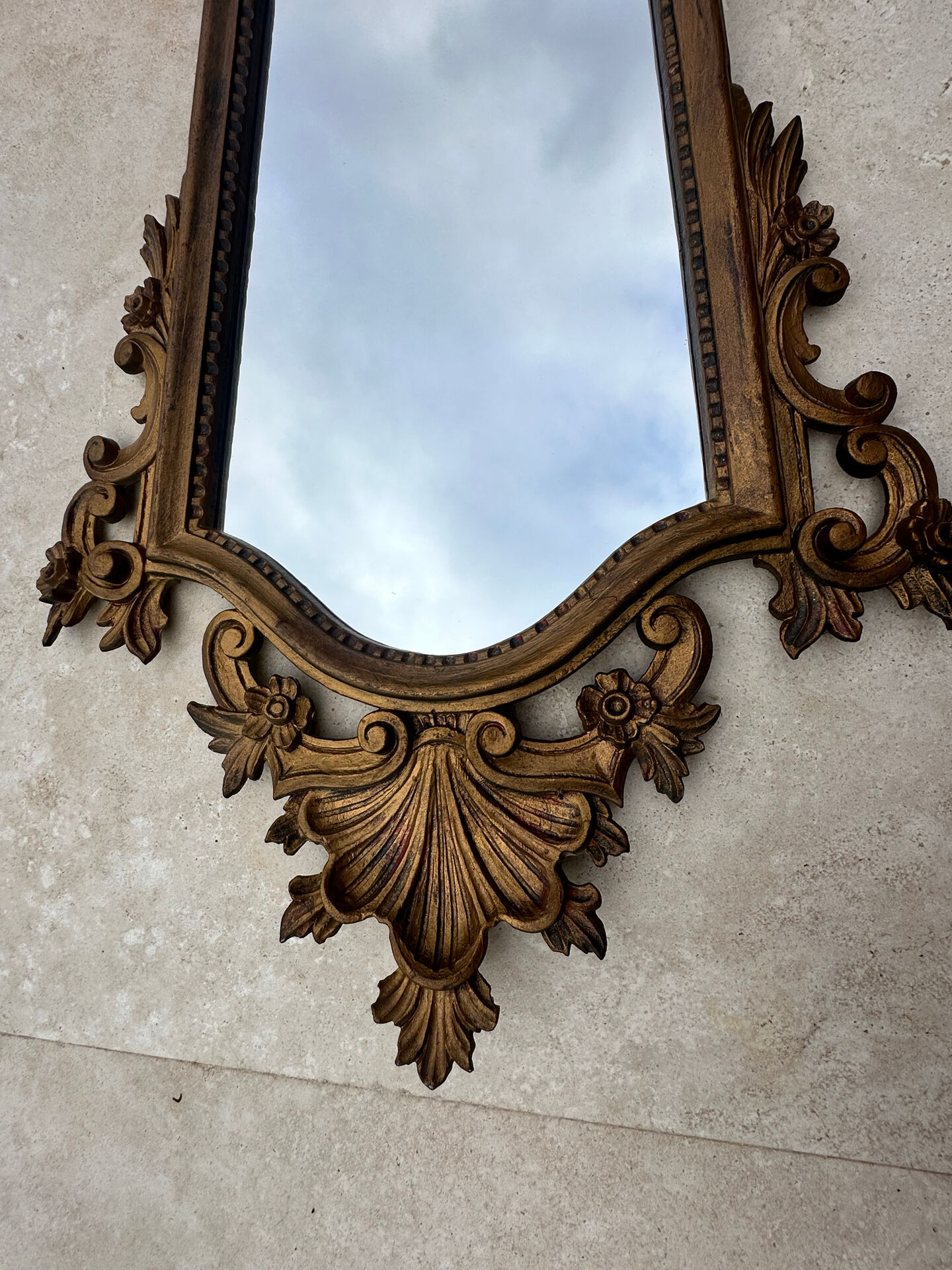 Carved and gilded wooden wall mirror.