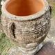 Large Cretan jar in terracotta with three handles on a stone base.