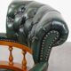 Classic green leather Chesterfield office chair on wheels.