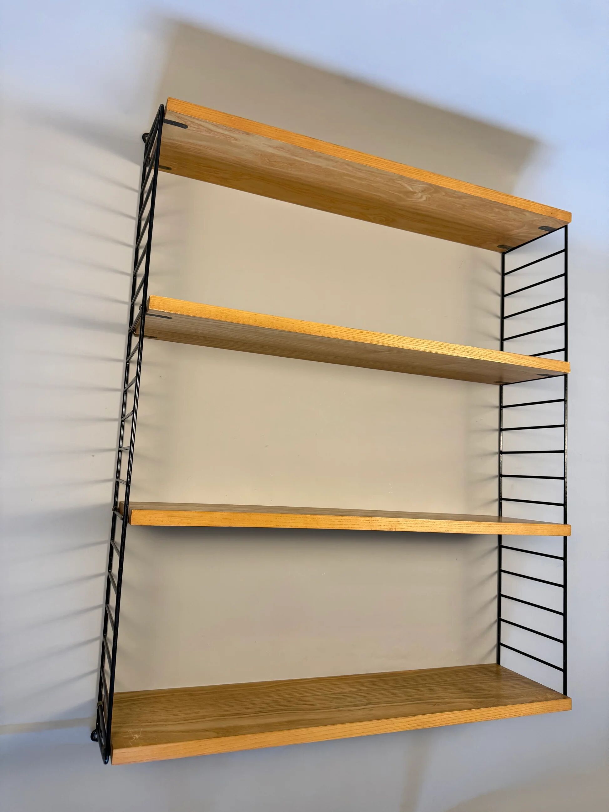 Floating wall shelf in oak veneer and black metal, 1960s.