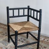 Antique black turned wood corner chair with a straw seat.