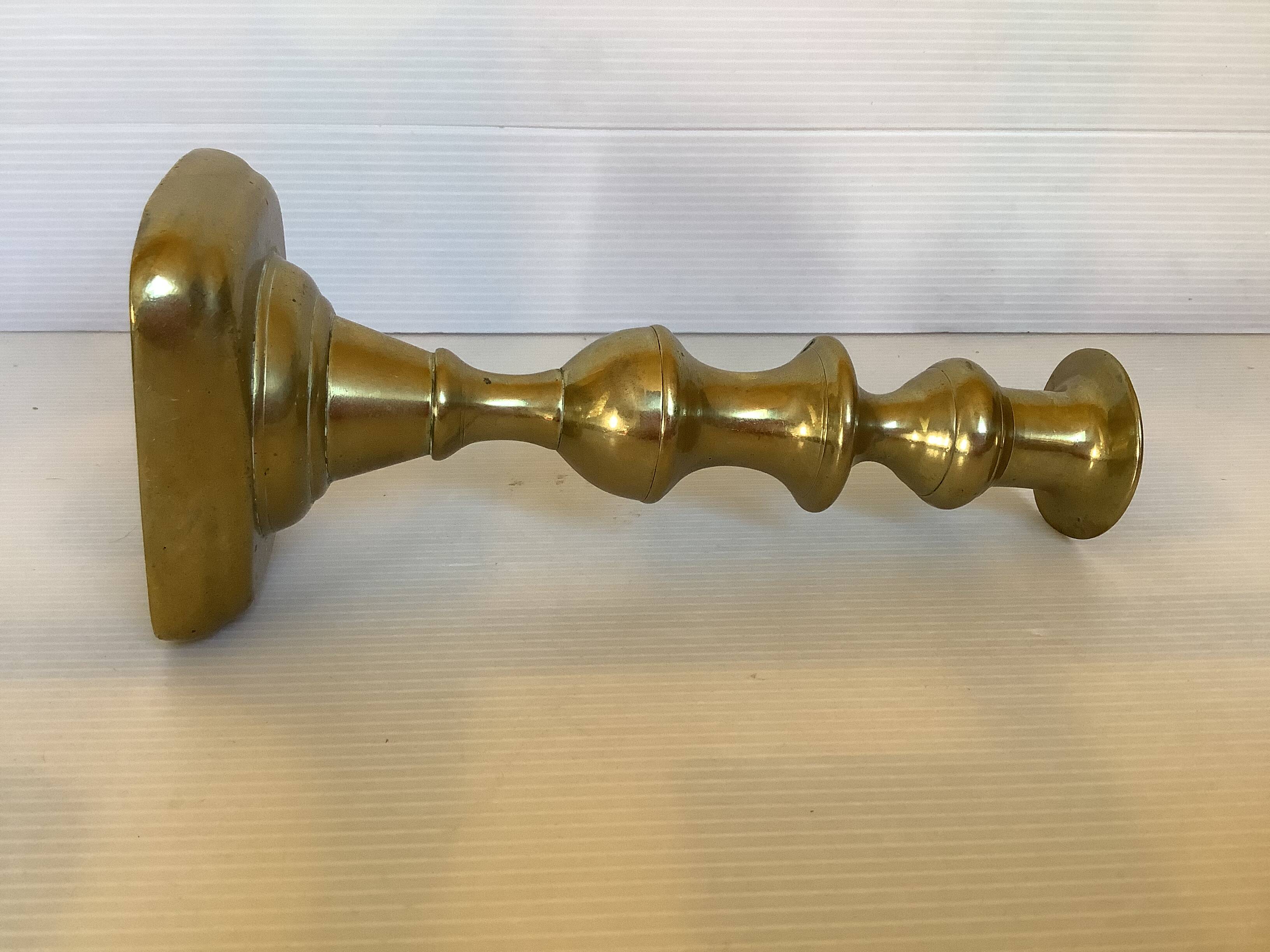 Brass candlestick with a rectangular base.