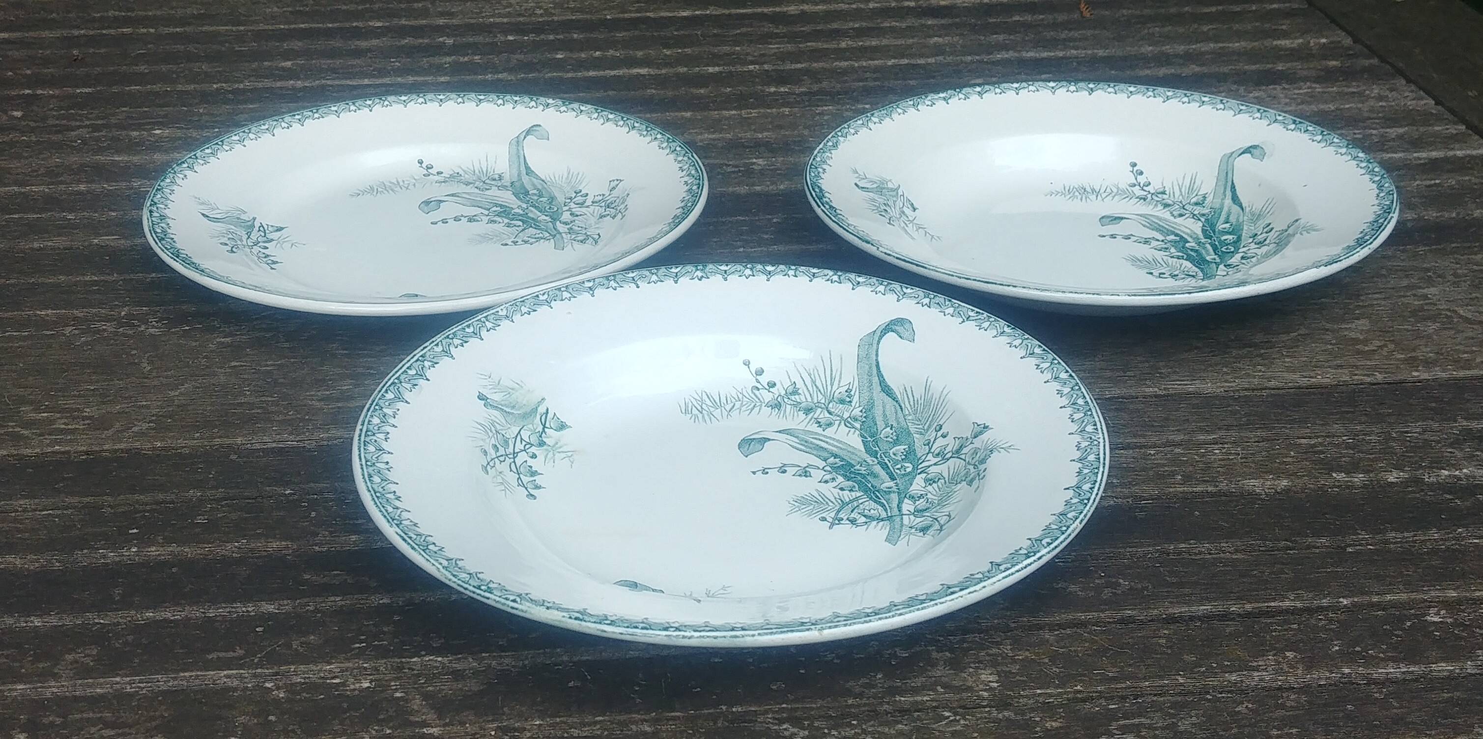 Set of three iron earthenware plates from the St Amandinoise earthenware factory, lily of the valley model.