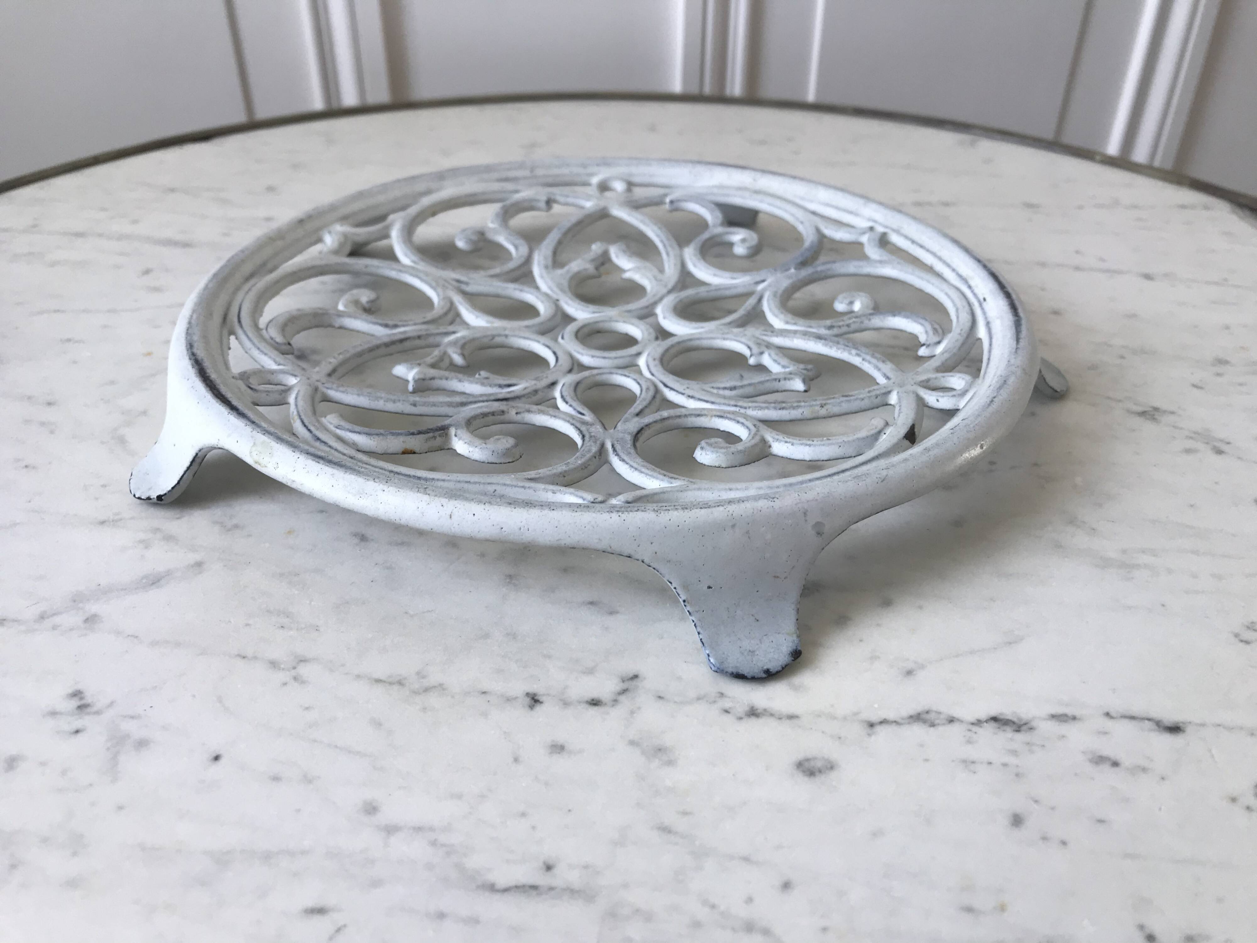 Vintage white cast iron trivet from the early 20th century